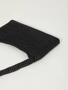 Close-up of minimalist black rhinestone mini shoulder bag with sparkling crystals and strap