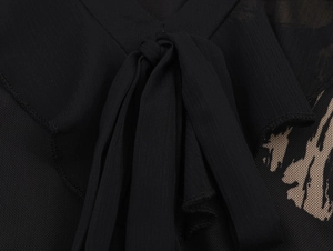Detailed view of black chiffon mesh fabric with drawstring bow and abstract print