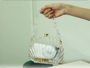 Details der transparenten Acryl-Abendtasche in Muschelform mit Goldverschluss