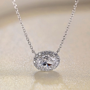 Gros plan d'un collier pendentif en zircon ovale avec sertissage halo étincelant