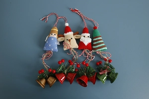 Detailed flat lay of handmade crochet Christmas ornaments with bells and holly berries