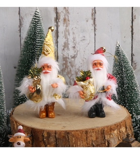 Detail of red and gold Santa Claus plush figurines standing on natural wood for Christmas decor