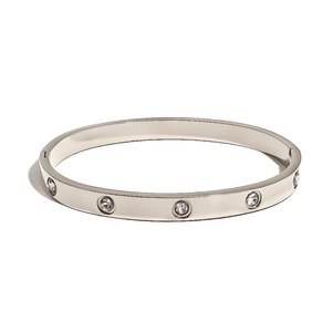 Macro detail of silver stainless steel bangle with set stones and geometric buckle