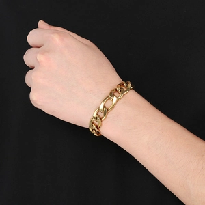 Close-up of a gold stainless steel 3:1 NK curb chain bracelet worn on a wrist