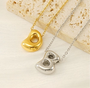 Detailed view of polished gold and silver organic bean pendants on delicate chains
