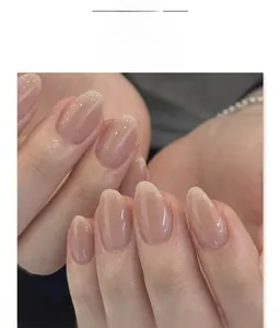 Close-up of nude pink almond press-on nails with a glossy translucent jelly finish