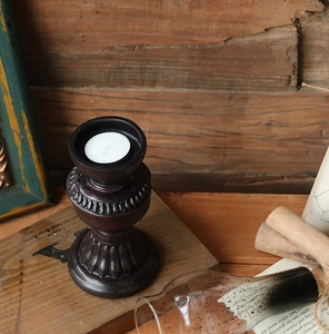 Close-up of vintage resin kerosene lamp model used as a candle holder on wood