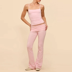 Dettaglio del top rosa e pantaloni a zampa a vita bassa in morbido tessuto elastico