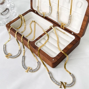 Luxury 18K gold plated snake chain necklace with zircon letters on a walnut jewelry box