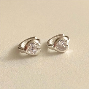 Macro detail of 925 sterling silver heart earrings with sparkling cubic zirconia stones