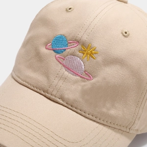 Beige cotton baseball cap with planet embroidery and detailed stitching texture