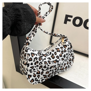 Detail of leopard print crescent bag with golden square zipper pull and metal hardware