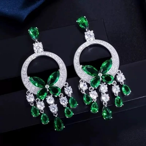 Détail de boucles d'oreilles cœur vintage avec zircons verts et fini argent