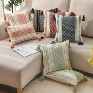 Detail of boho tufted cushion covers with geometric textures and colorful tassels