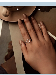 Detailed view of an 18K gold-plated heart-shaped open ring worn in a cozy setting
