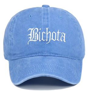 Close-up of white Bichota gothic embroidery on light blue washed cotton baseball cap