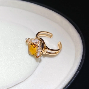 Detail of adjustable gold ring with amber gemstone, tiny pearls and crystals in a box