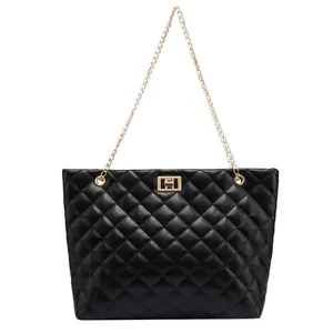 Close-up of black quilted leather tote with gold chain strap and turn-lock buckle