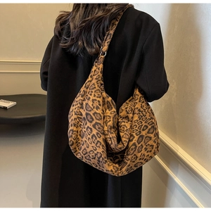 Detail of leopard print hobo shoulder bag in soft fabric styled on a model's shoulder