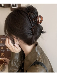 Grande pince à cheveux en résine écaille de tortue sur cheveux bruns pour un look chic