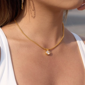 Elegante collana in acciaio al titanio dorato con ciondolo in zircone tondo sulla clavicola