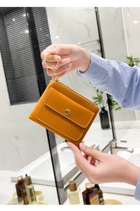 Detail of yellow PU leather coin purse with zipper and front flap snap pocket