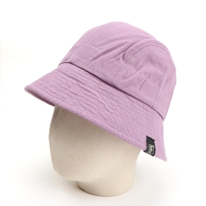 Detail view of purple canvas bucket hat on mannequin head featuring black label stitching