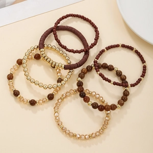 Detail of 7-piece bohemian beaded bracelet set in amber, brown, and gold tones