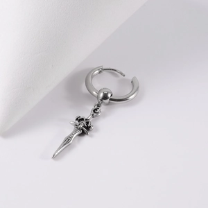 Macro view of a polished stainless steel hoop earring featuring a vintage sword pendant