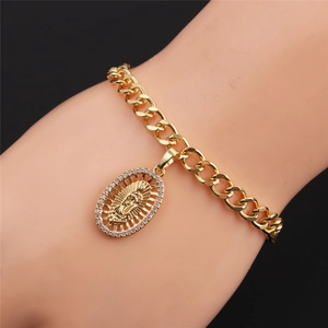 Primo piano del bracciale a catena cubana dorata con ciondolo Madonna sul polso del modello