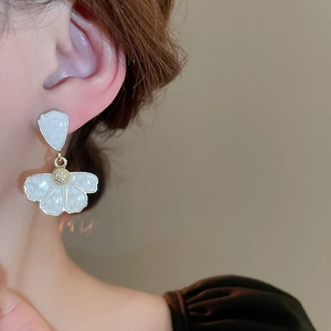 Sweet white petal flower earrings with gold bead center worn by a female model
