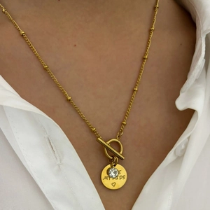 Gold stainless steel T-bar necklace with 'MY KIDS' engraved heart coin on a woman