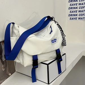 White large capacity messenger bag with blue shoulder strap and checkerboard pendant