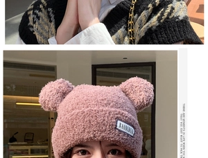 Detailed texture of pink plush knit hat with cute bear ears and brand label detail
