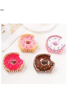 Detail view of donut-shaped acrylic hair claw clips with colorful sprinkles in four colors