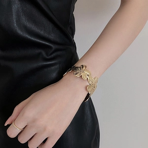 Detail view of vintage gold flower cuff bracelet with brushed metal floral texture