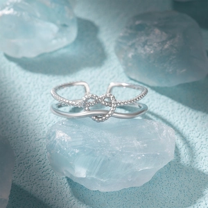 Macro detail of S925 silver ring featuring heart infinity knot on blue stone