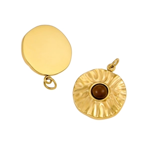 Detail of round gold stainless steel pendants with smooth and wavy textured surfaces