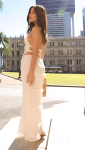 Detailed view of white sleeveless halter neck top and layered tiered maxi skirt set