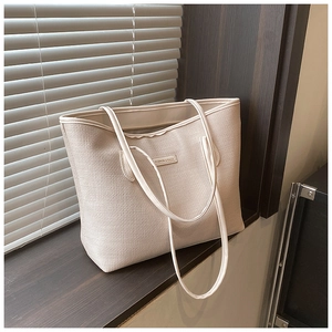 Detail of beige tote bag with woven texture and Fashion & Bags label in natural light