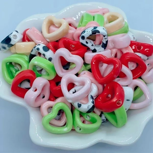 Macro shot of assorted colorful heart-shaped ceramic DIY beads in a shell-shaped dish
