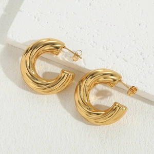Luxurious 14K gold plated twisted rib chunky C-shape hoop earrings on a stone surface