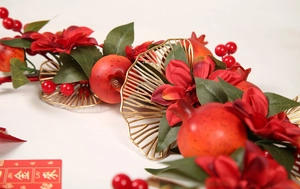 Détail d'une couronne de grenade festive avec feuilles de ginkgo dorées et fleurs