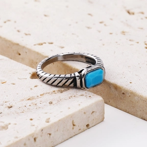 Macro detail of vintage 18k gold ring with blue square gemstone and textured metal