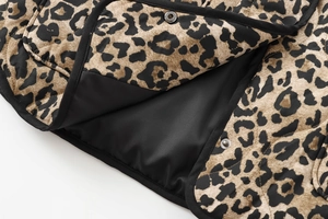 Close-up of leopard print jacket showing quilted black lining and metal snap buttons