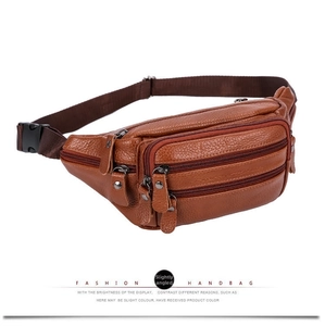 Detail of brown leather fanny pack showing three zipper compartments and adjustable belt