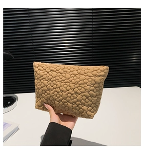 Detailed close-up of khaki floral quilted makeup bag featuring soft fabric texture
