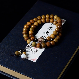 Detailed close-up of double-layered sandalwood beads with lotus tassels and wood grain