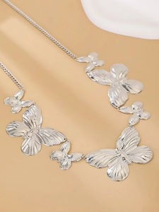 Macro shot of silver butterfly pendants with detailed wings on a bohemian waist chain