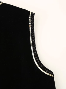 Detail shot of black velvet vest featuring golden sequin trim on the collar and armholes